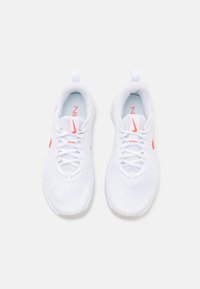 Zapatillas deportivas de malla blanca con detalles en rosa. Cuentan con cordones, acolchado alrededor del cuello y una suela texturizada para mayor tracción.