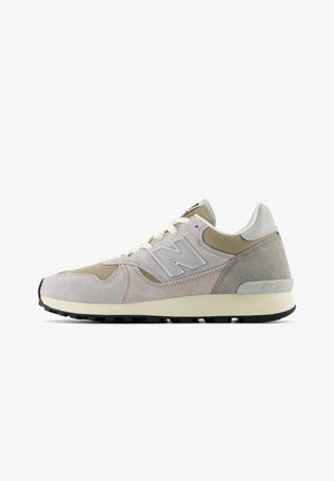 Sneakers beige e grigie con tomaia in pelle scamosciata e mesh, caratterizzate da un logo 'N' ben visibile, lacci, dettagli testurizzati e suola in gomma.