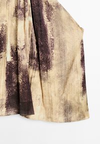 Hnědá a béžová látka s vzorem herringbone; má sklady a přirozený spad.