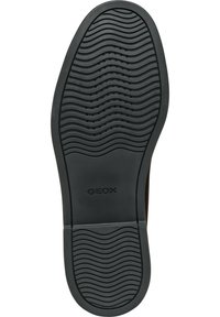 Semelle de chaussure en caoutchouc noir avec un motif de bande de roulement ondulé et des trous de drainage. Présente le logo "GEOX" en relief près du talon.