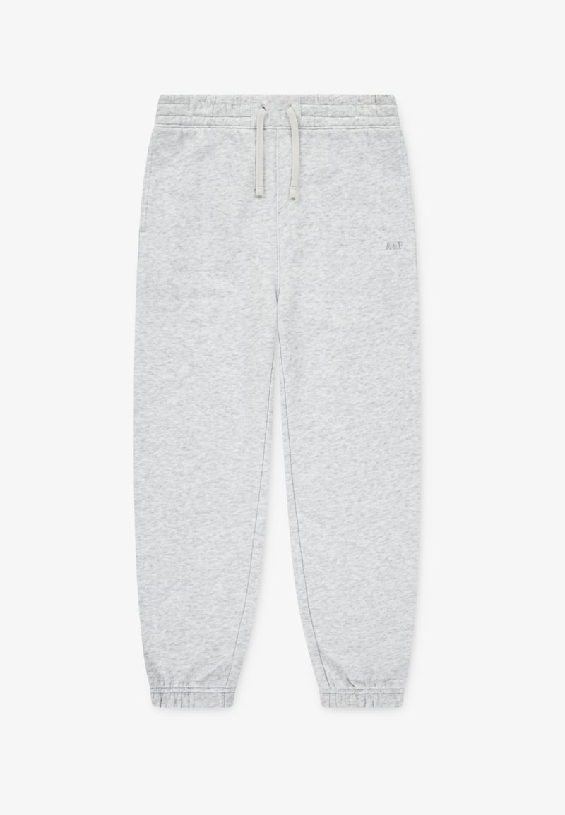 Lys grå joggebukser laget av mykt stoff, med snor i livet, elastiske mansjetter og en liten logo foran.