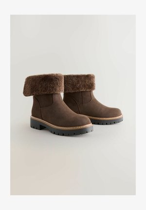 Pruunid sametised pahkluu saapad pehme, karvja äärega, kontrastõmblustega ja vastupidava musta kummist tallaga, millel on libisemisvastased musterid.