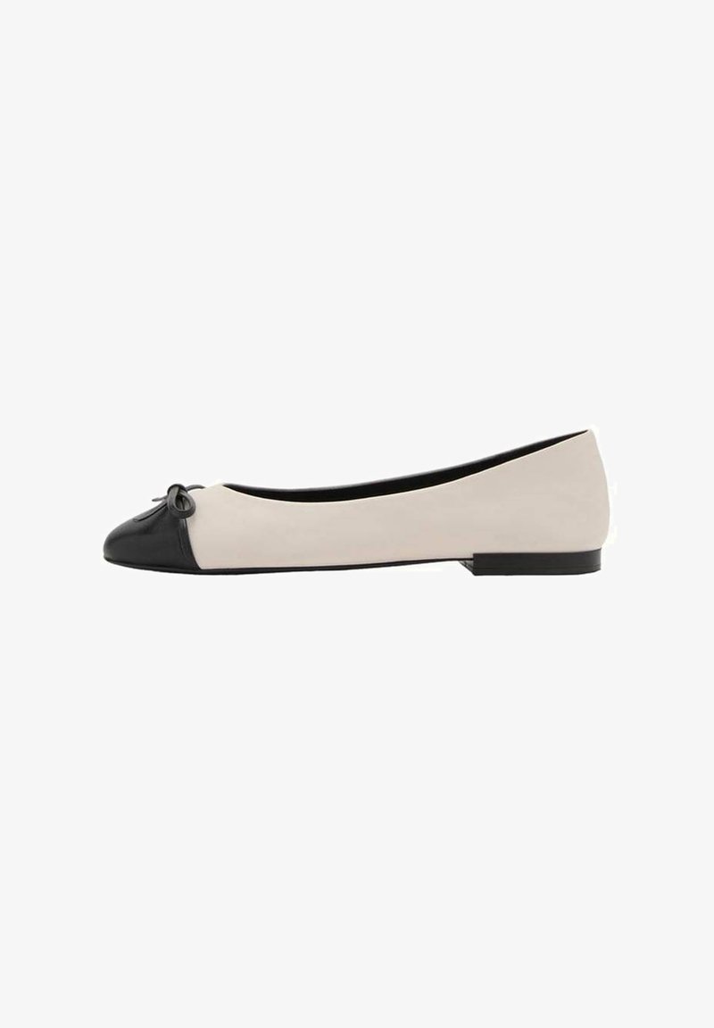 Dames platte schoen met een beige lichaam, zwarte neuskap, een klein zwart strikje en een lage zwarte hak, weergegeven in zijprofiel.