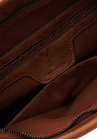 Interno di una borsa in pelle marrone con molteplici scomparti, dotato di una tasca con zip e rivestimento in tessuto testurizzato. Dettaglio del logo impresso presente.