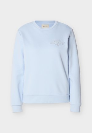 Svetlo modra majica z dolgimi rokavi z rebrastimi manšetami in spodnjim robom, z majhnim izvezenim logotipom GANT na levi strani prsnega koša.