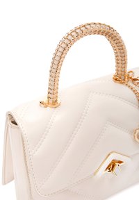 Borsa a mano in pelle bianca con motivo trapuntato, manico in catena dorata e un accento geometrico dorato. Presenta una chiusura a patta con dettagli cuciti.