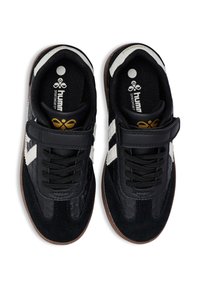 Scarpe sportive nere con tomaia in pelle scamosciata e liscia, caratterizzate da strisce bianche e una fascia a strappo. Suola texturizzata, collarino imbottito e dettaglio con logo.