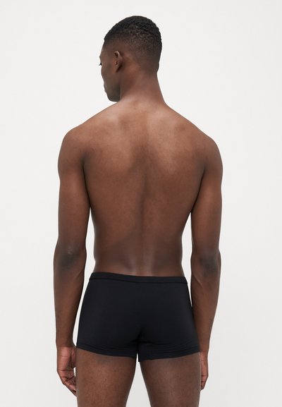 Schwarze Boxer-Shorts mit engem Sitz, aus weichem Stoff gefertigt. Der Bund ist einfach, und das Design verfügt über einen niedrigen Schnitt an den Oberschenkeln.