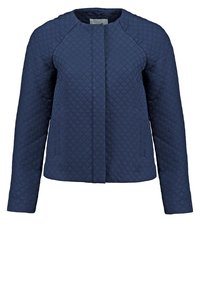 Veste matelassée bleu marine à manches longues, col rond et fermeture avant dissimulée.