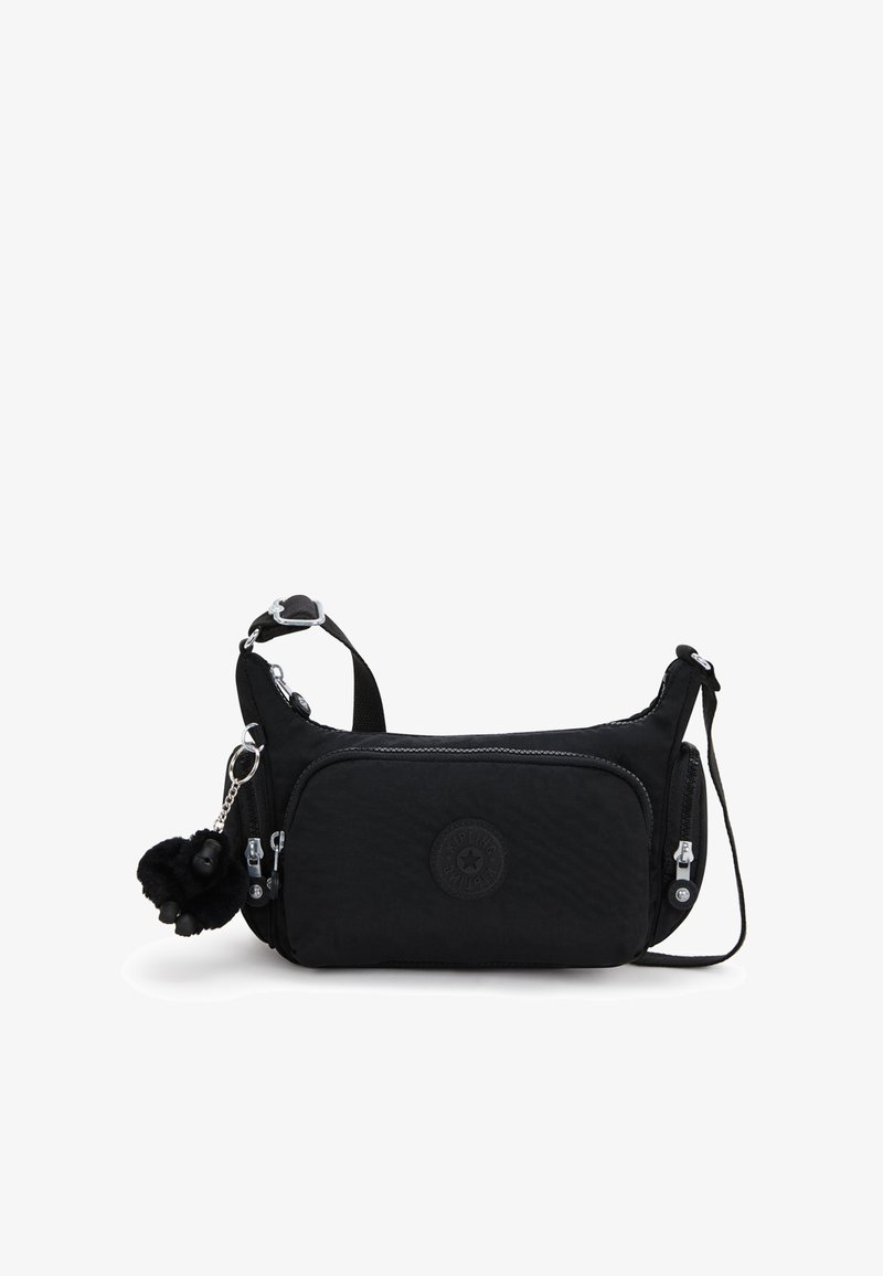 Černá nylonová taška přes rameno s texturovaným povrchem, dvěma kapsami na zip, kulatou nášivkou s logem a plyšovým přívěskem ve tvaru bambule.