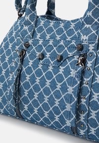 Sac à main en tissu bleu avec motif géométrique blanc, poche avant zippée, clous argentés et tirettes de fermeture éclair en métal.