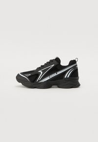 Black athletic sneakers with mesh and synthetic materials. Features a rounded toe, thick sole, and reflective white accents on the sides.