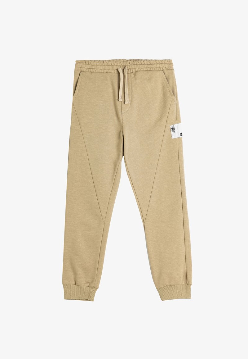 Beige sweatpants lavet af en bomuldsblanding, med elastisk talje, sidelommer, tapered ben og et firkantet label på venstre lår.