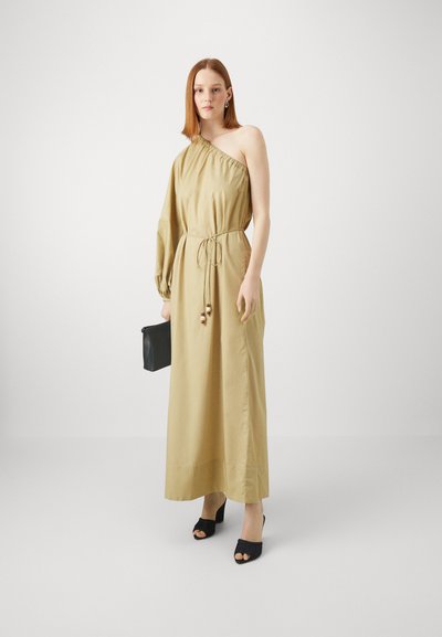 Asimetriška smėlinė suknelė su viena petneša, su elastinga juosta, priveržta su raišteliu. Dėvima su juodais aukštakulniais ir juodu rankine.