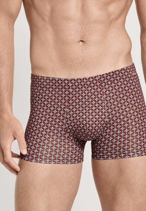 Boxer shorts marron avec un motif géométrique en bleu et rouge. Fabriqués en tissu extensible, ils présentent un design ajusté et une taille élastique.