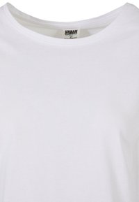 T-shirt bianco in cotone con scollatura rotonda e maniche corte. Tessuto liscio, design minimale, etichetta visibile all'interno con il nome del marchio "Urban Classics."