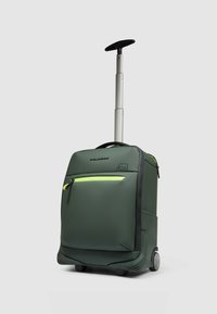 Valigia trolley verde scuro, con manico retrattile in argento, una tasca frontale con cerniera gialla e una texture liscia.