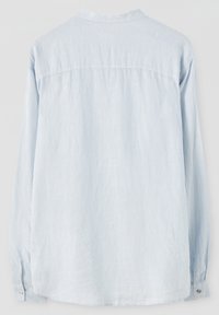 Jasnoniebieska koszula z długim rękawem wykonana z miękkiego materiału, o luźnym kroju, z mankietami na guziki i detalem tylnym na karku. Gładka tekstura.