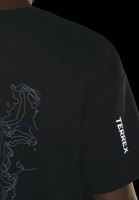 Black t-shirt featuring a white contour map design on the back, with blue and orange accents. "TERREX" printed in white on the sleeve.