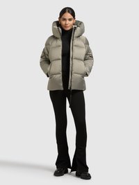 Kurtka puchowa w jasnoszarym kolorze z wysokim, puszystym kapturem, pikowanym wzorem, przednim zamkiem błyskawicznym i bocznymi kieszeniami, noszona na czarnym golfie i spodniach.