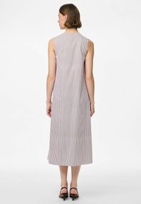 Vestido midi sin mangas en un color claro con rayas verticales. Presenta un diseño limpio, tejido suave y un corte holgado. Longitud a media pantorrilla.