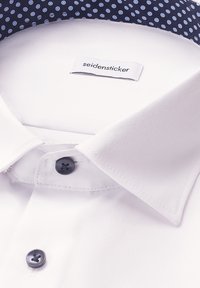 Witte overhemd met een marineblauwe kraag met stippen, voorzien van een Seidensticker-label en zwarte knopen, met een gladde textuur en een strakke uitstraling.