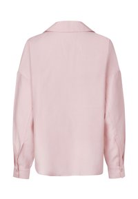 Světle růžová blůza s volným střihem, dlouhými rukávy a klasickým límečkem. Má zapínání na knoflíky na manžetách a hladkou, jemnou texturu.