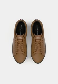 Paire de baskets en cuir marron Tommy Hilfiger avec lacets, doublure intérieure noire et semelles en caoutchouc blanches vues de dessus.