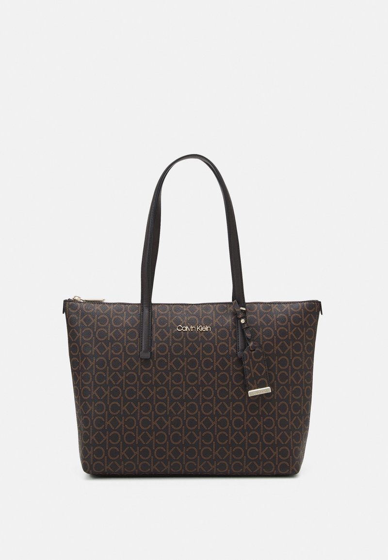 Borsa a spalla marrone con logo Calvin Klein, caratterizzata da un esterno decorato, manici neri doppi e una chiusura con zip con un'etichetta removibile.