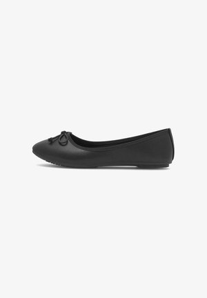 Black ballet flat with rounded toe, small bow detail on front, low heel, and textured sole, shown in side profile on white background.
