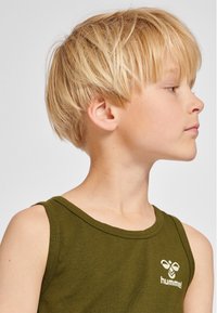 Olivengrijnse tanktop met een afgeronde halslijn en brede schouderbanden. Heeft een wit logo aan de linkerkant van de borst. Gladde katoenstructuur.