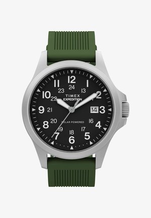 Hodinky Timex Expedition s čiernym ciferníkom, bielymi číslicami, zobrazením dátumu na pozícii 3 hodiny, strieborným puzdrom a textúrovaným zeleným silikónovým remienkom.