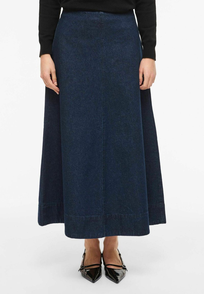 Długa spódnica maxi z ciemnoniebieskiego denimu o prostej sylwetce, z bocznymi szwami i gładnym dołem. Tekstura tkaniny jest gładka, z subtelnymi detalami przeszyć.