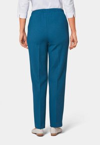 Blauwe, geribbelde pull-on broek met een relaxte pasvorm. De tailleband is elastisch voor extra comfort. Effen achterkant, taps toelopend naar de enkel.