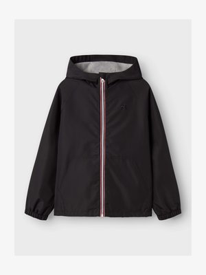 Fekete kapucnis dzseki elöl cipzárral, amelyet piros, fehér és kék szegély díszít, elasztikus mandzsettákkal és elülső zsebekkel, fehér háttéren bemutatva.