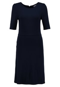 Mörkblå klänning med kort ärm, rund halsringning och en figursydd midja. Mjukt tyg med en slät textur och knälång kjol.