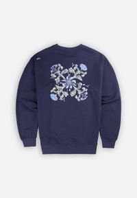 Sweatshirt marine avec une broderie florale détaillée en bleu et crème au dos, avec des poignets et un ourlet côtelés.