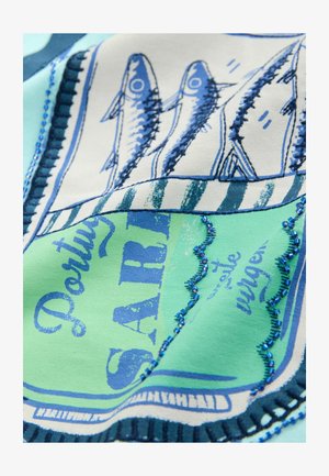 Tessuto stampato con illustrazioni di pesci blu su uno sfondo verde e crema, arricchito con accenti di perline blu e cuciture testurizzate.