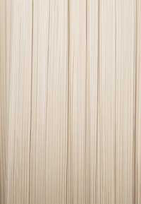 Plis verticaux sur un tissu beige créant un motif texturé à rayures avec de douces ombres entre les plis.