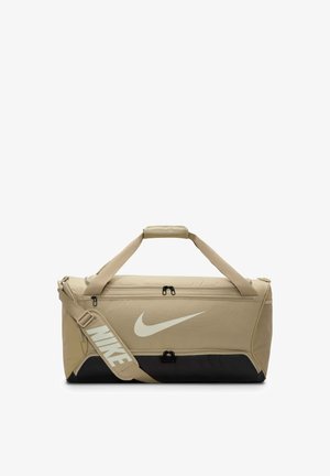 Sac de sport beige avec une base noire, doté de fermetures à glissière doubles, de poignées supérieures et d'une bandoulière réglable avec un logo Nike blanc.