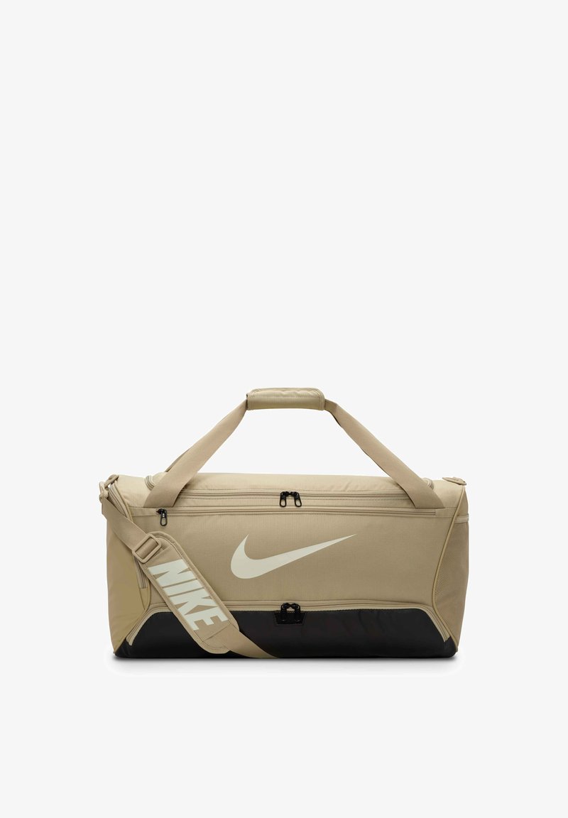 Borsa a duffel beige con base nera, dotata di doppie chiusure con zip, manici superiori e una tracolla regolabile con il logo Nike bianco.