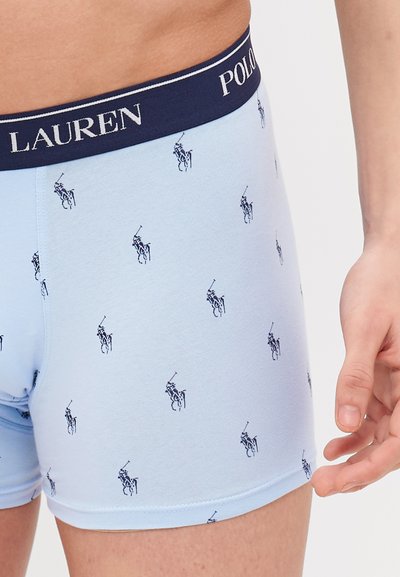 Šviesiai mėlyni medvilniniai šortai, su tamsiai mėlynu diržu, ant kurio yra tekstas "POLO LAUREN" ir kartotiniai maži tamsiai mėlyni arkliukai.