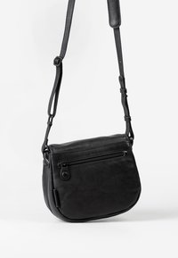 Borsa a tracolla in pelle nera con forma curvata, tracolla regolabile, tasca frontale con zip e texture liscia. Design minimalista senza loghi visibili.