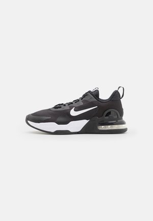 Black athletic shoe with mesh upper, white Nike swoosh, visible air unit in heel, textured rubber outsole, and lacing system.