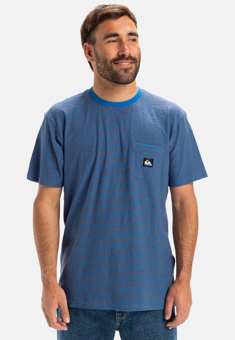 Modrý pruhovaný tričko s kulatým výstřihem a kapsou na hrudi, vyrobené z bavlny. Obsahuje logo na kapse a kontrastní manžety.