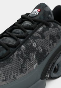 Fekete és szürke mintázatú sneaker, texturált hálós felsőrésszel, fekete fűzőkkel és a nyelven jól látható Air Max logóval. Lekerekített talp.