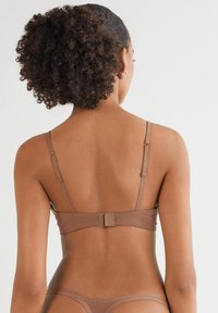 Hnědý bralet s nastavitelnými ramínky, zapínáním na háček a oko, hladkým povrchem a minimalistickým designem. Pohled ze zad ukazuje čisté linie a přiléhavý tvar.