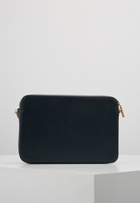 Obdélníková crossbody taška z texturované tmavě námořnické kůže se zlatými kovovými detaily. Obsahuje zipové uzavření a hladké, strukturované okraje.