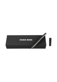 Melns Hugo Boss uzpildāmais pildspalva ar teksturētu rokturi, vāciņš noņemts, atpūšas uz zīmola melnas kastes uz baltā fona.