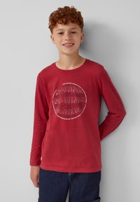 Rode longsleeve shirt van katoen, met een cirkelvormige graphic waarop herhaald de tekst "SOUND" in verschillende lettertypen en maten staat.